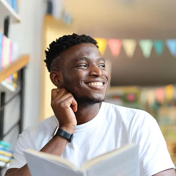 Person smiling while reading a book
